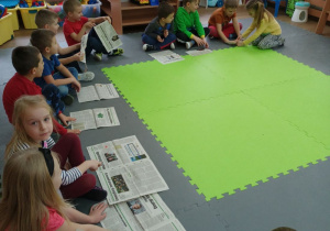 Dzieci wystukują rytm na gazetach